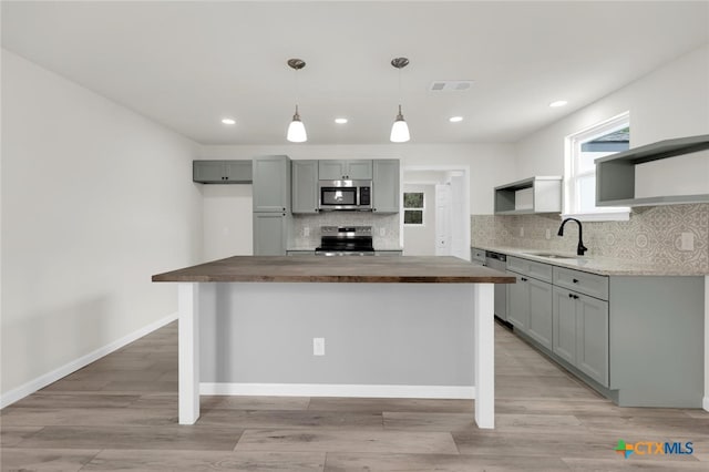 760 Lookout Dr, Canyon Lake, TX 78133 - kitchen featuring appliances with stainless steel finishes, open shelves, wood counters, backsplash, and a kitchen island