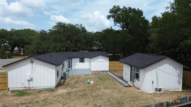 760 Lookout Dr, Canyon Lake, TX 78133 - back of house featuring a fenced backyard, a shingled roof, and an outbuilding