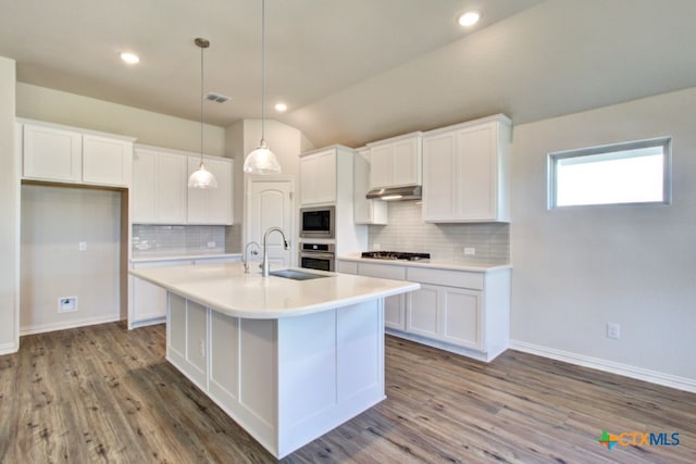 kitchen with sink, white cabinetry, appliances with stainless steel finishes, and lofted ceiling