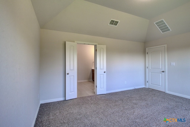 unfurnished bedroom featuring carpet floors and lofted ceiling