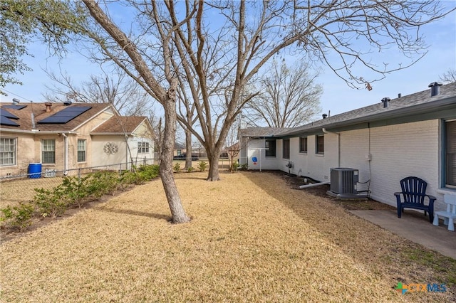 view of yard featuring central AC and fence