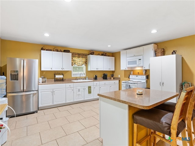 4386 Morningside Way, Canyon Lake, TX 78133 - kitchen with white appliances, a breakfast bar, white cabinets, a center island, and recessed lighting