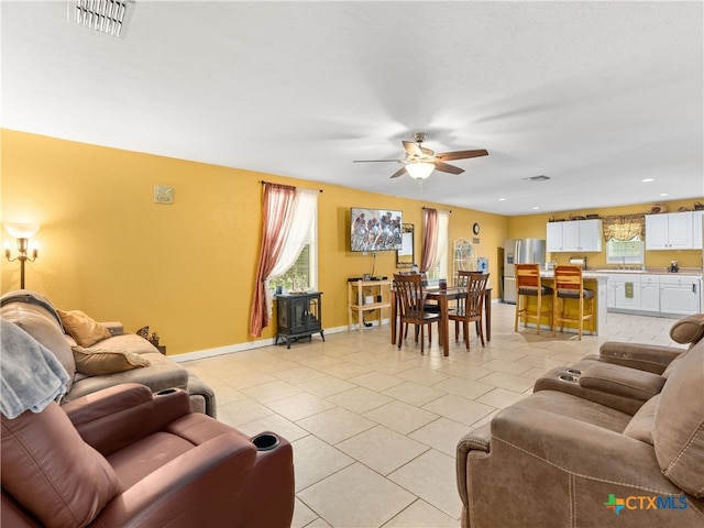 4386 Morningside Way, Canyon Lake, TX 78133 - living room with a wood stove, ceiling fan, and light tile patterned floors