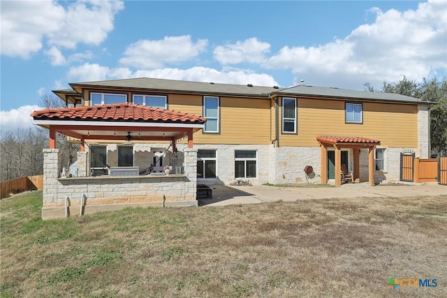 rear view of house featuring a patio, ceiling fan, and a lawn