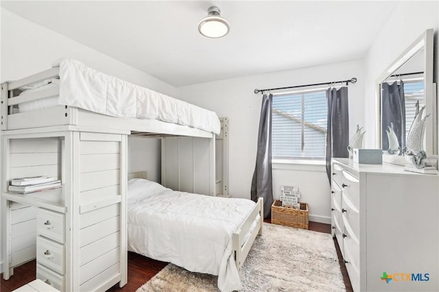 bedroom with dark hardwood / wood-style floors