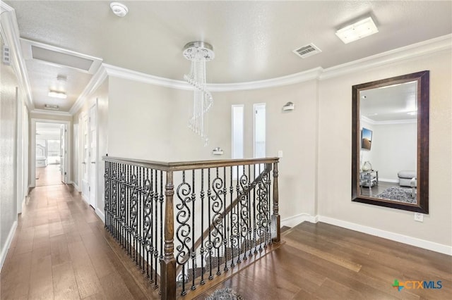 hallway featuring dark hardwood / wood-style flooring, crown molding, and a textured ceiling