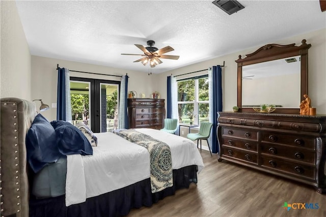 326 Riverview Rd, Mcqueeney, TX 78123 - bedroom featuring wood finished floors, a textured ceiling, access to outside, french doors, and a ceiling fan