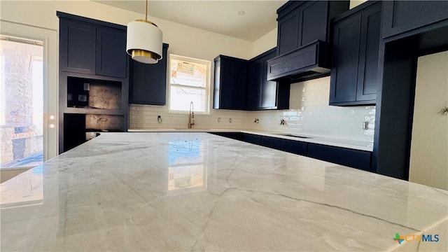 366 Meadow Valley Loop, Jarrell, TX 76537 - kitchen featuring decorative backsplash, black electric stovetop, light stone countertops, sink, and decorative light fixtures