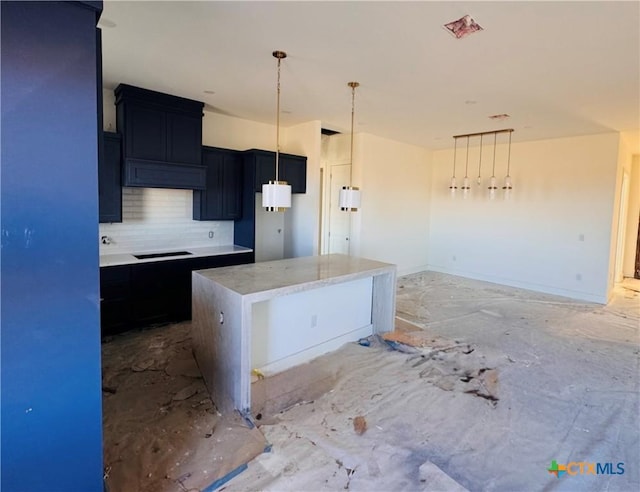 kitchen featuring black electric stovetop, backsplash, a kitchen island, and hanging light fixtures