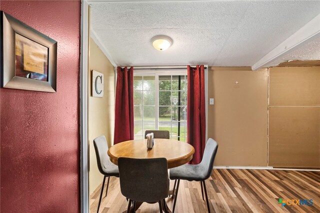 921 S Laurel Ave, Luling, TX 78648 - dining area featuring wood finished floors, a textured ceiling, and baseboards