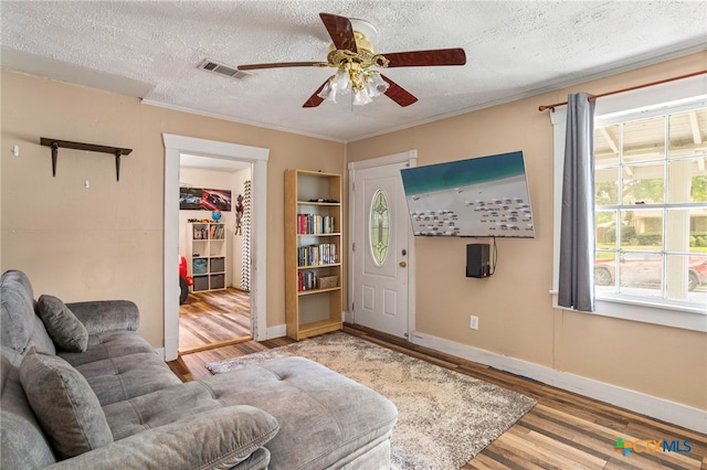 921 S Laurel Ave, Luling, TX 78648 - living room with wood finished floors, ceiling fan, a textured ceiling, baseboards, and ornamental molding