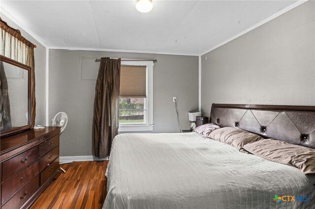 921 S Laurel Ave, Luling, TX 78648 - bedroom with dark wood-style flooring, baseboards, and crown molding
