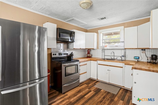 921 S Laurel Ave, Luling, TX 78648 - kitchen with stainless steel appliances, a sink, butcher block countertops, dark wood-style flooring, and a textured ceiling