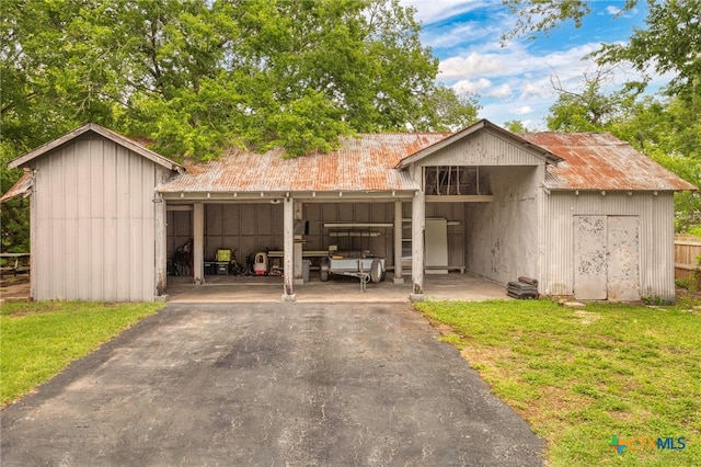 921 S Laurel Ave, Luling, TX 78648 - view of front of home featuring an outbuilding, a carport, driveway, and metal roof