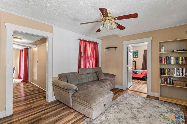 921 S Laurel Ave, Luling, TX 78648 - living area featuring wood finished floors, ceiling fan, a textured ceiling, crown molding, and baseboards