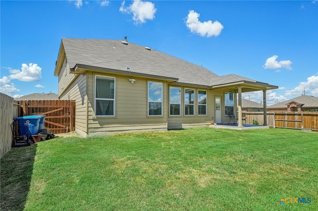 back of house with a patio and a yard