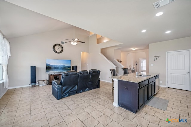 kitchen with lofted ceiling, a center island with sink, dishwasher, sink, and ceiling fan