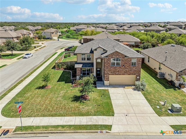 view of front of house with a front lawn, a garage, and central AC