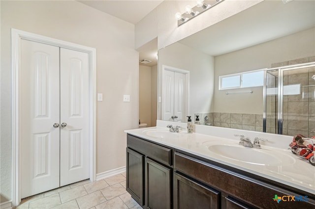 bathroom with walk in shower, vanity, and tile patterned floors