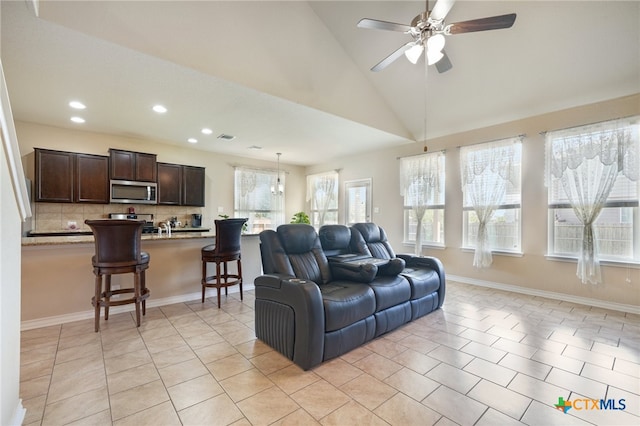 tiled living room with high vaulted ceiling and ceiling fan