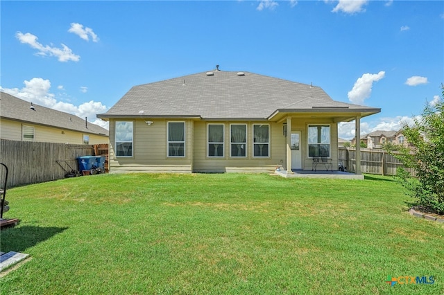 rear view of house featuring a lawn and a patio area