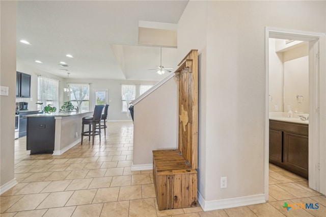 interior space featuring sink, tile patterned flooring, and ceiling fan with notable chandelier