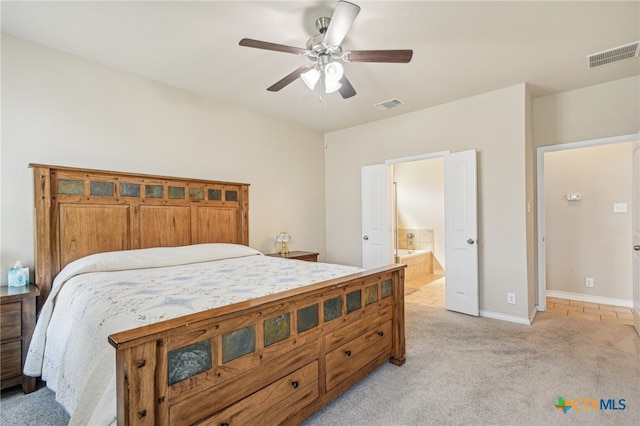 carpeted bedroom with ensuite bathroom and ceiling fan