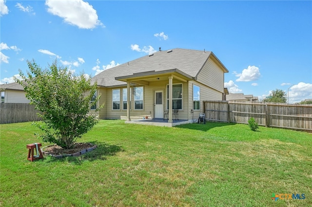 back of property with a patio area and a lawn