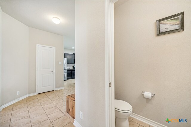 bathroom featuring toilet and tile patterned flooring