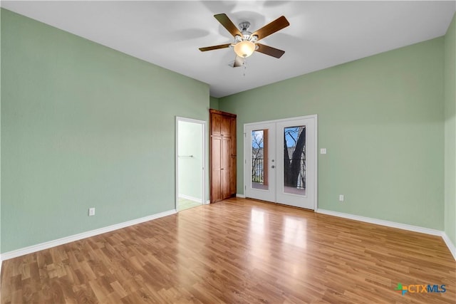 spare room with ceiling fan, french doors, light wood-type flooring, and baseboards