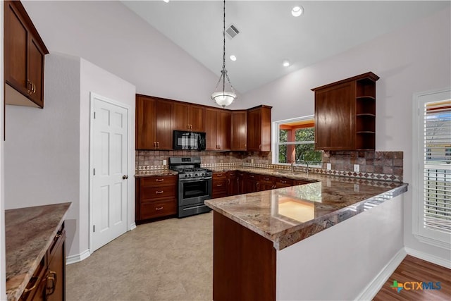 kitchen with light stone counters, open shelves, lofted ceiling, stainless steel gas range, and black microwave