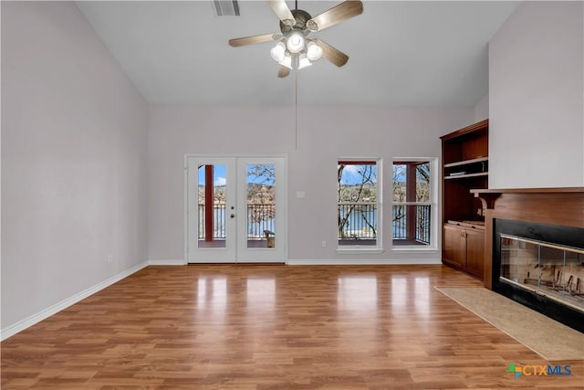 unfurnished living room featuring a fireplace with flush hearth, visible vents, baseboards, french doors, and light wood-type flooring