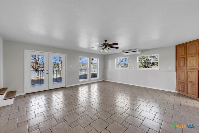 interior space with ceiling fan, french doors, a wall mounted air conditioner, and baseboards