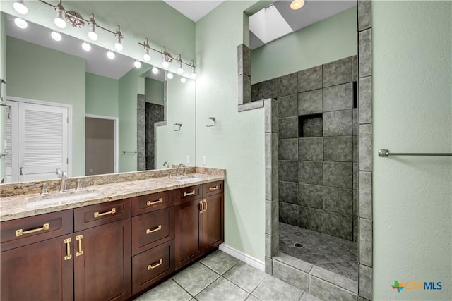 full bathroom with double vanity, walk in shower, a sink, and tile patterned floors