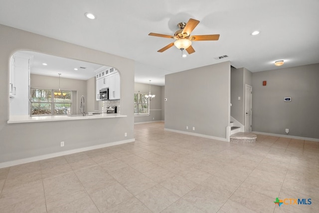 unfurnished living room featuring ceiling fan, light tile patterned flooring, and sink