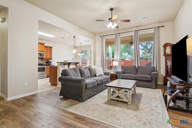 2005 Red Fox Dr, Nolanville, TX 76559 - living room featuring a ceiling fan, light wood-style flooring, and baseboards