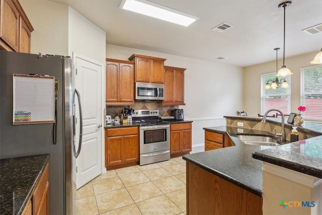 2005 Red Fox Dr, Nolanville, TX 76559 - kitchen featuring appliances with stainless steel finishes, a sink, decorative backsplash, and brown cabinets
