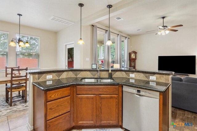 2005 Red Fox Dr, Nolanville, TX 76559 - kitchen with dishwasher, open floor plan, a sink, brown cabinets, and dark stone countertops