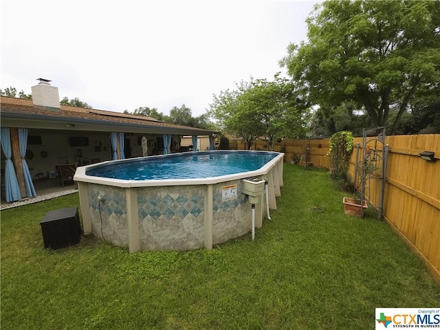 view of swimming pool with a yard