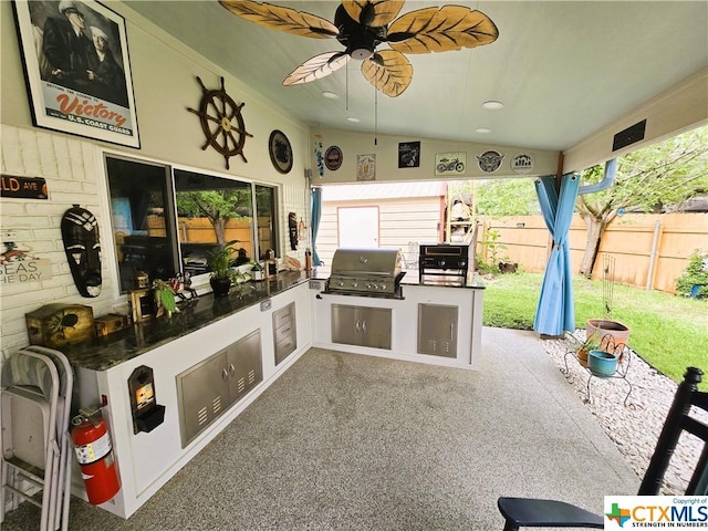 view of patio featuring ceiling fan, a grill, and exterior kitchen