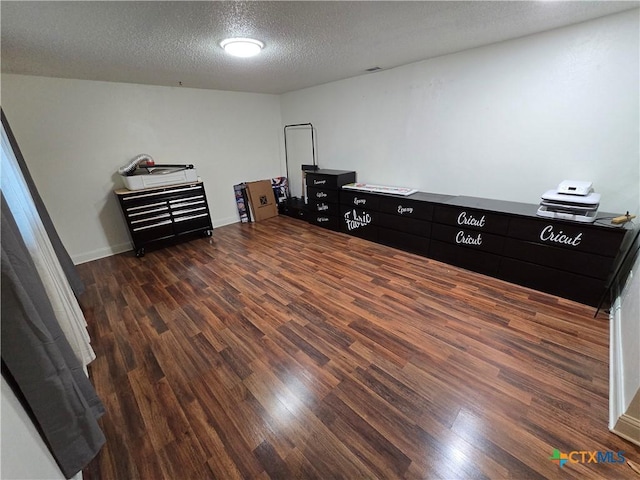 interior space featuring dark wood-type flooring and a textured ceiling