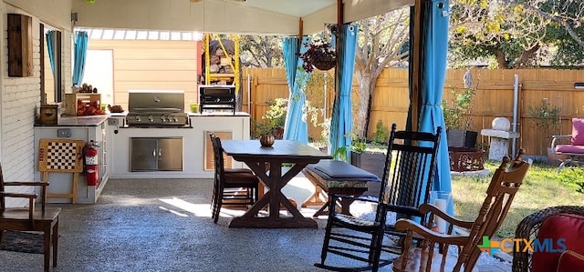 view of patio / terrace featuring a bar, a grill, and exterior kitchen