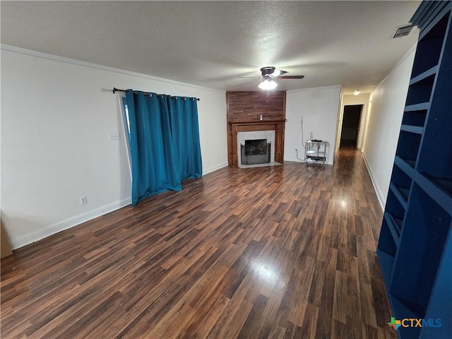 unfurnished living room featuring dark wood-type flooring, a fireplace, a textured ceiling, and ceiling fan