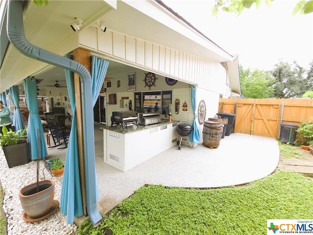 view of patio featuring ceiling fan and an outdoor kitchen