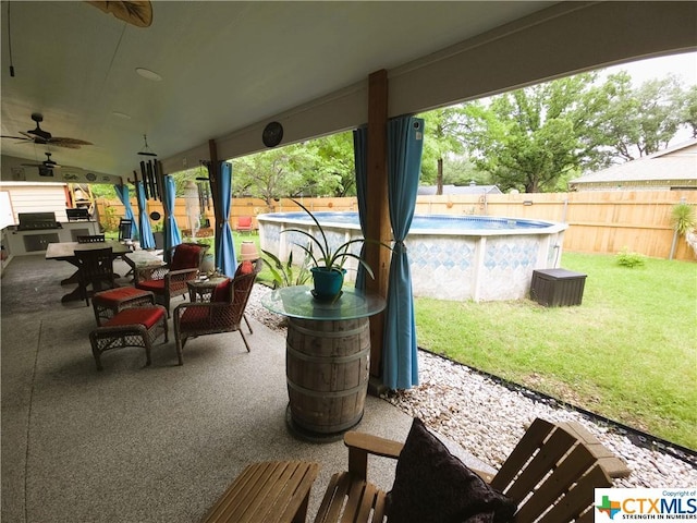 view of patio / terrace with ceiling fan and a fenced in pool