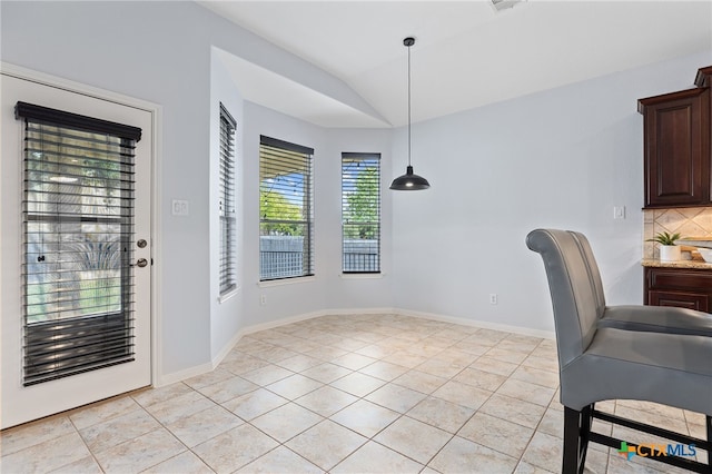 2129 Aaron Ross Way, Round Rock, TX 78665 - unfurnished dining area featuring light tile patterned flooring, lofted ceiling, and baseboards