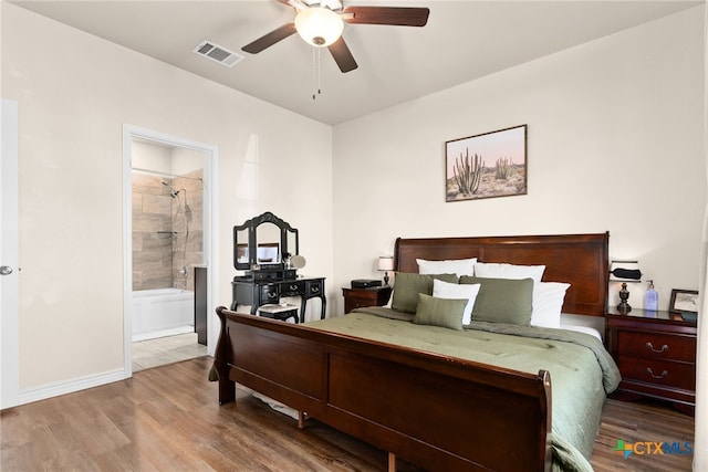 bedroom with hardwood / wood-style floors, ensuite bathroom, and ceiling fan