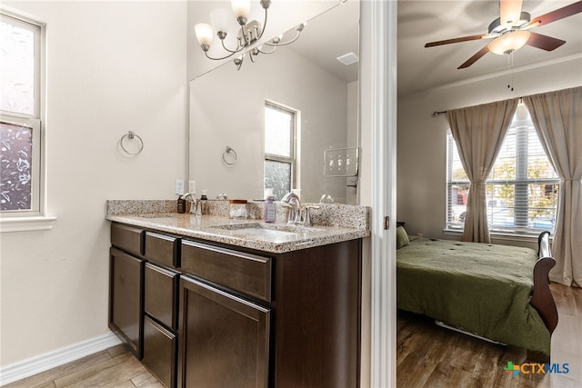 bathroom featuring hardwood / wood-style floors, ceiling fan with notable chandelier, and vanity