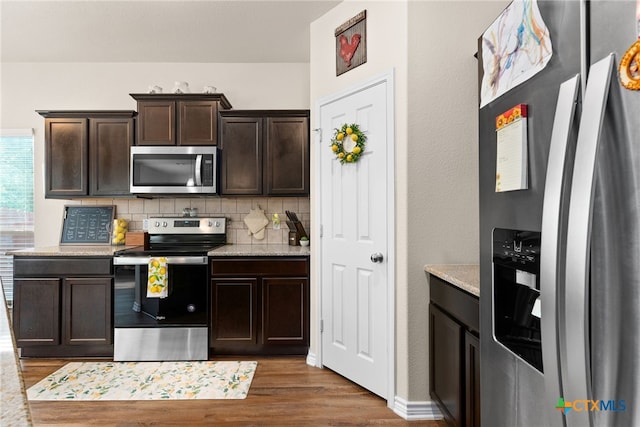 kitchen featuring backsplash, hardwood / wood-style floors, dark brown cabinets, and stainless steel appliances