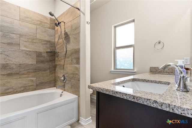 bathroom featuring vanity and tiled shower / bath